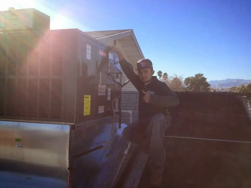 HVAC technician performing Boiler Repair on a rooftop unit in Shawnee